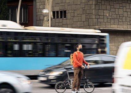 Bike-riding man wearing face mask in the city