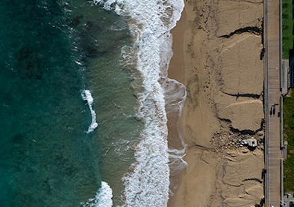 Aerial view of ocean waves breaking on a sandy beach