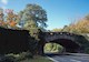 Image shows a four-lane parkway. Autumn-colored trees dot the landscape in the background. 