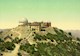 Image shows a rooftop facility consisting of a multistory building, two domed structures, and housing. A road leads to the top of the mountain. 