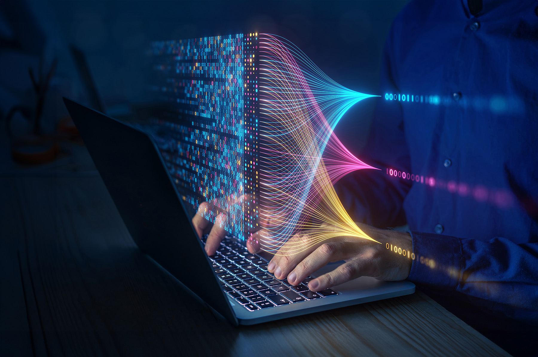 Hands type at a keyboard. IN the foreground is an array of zeros and ones in various colors.