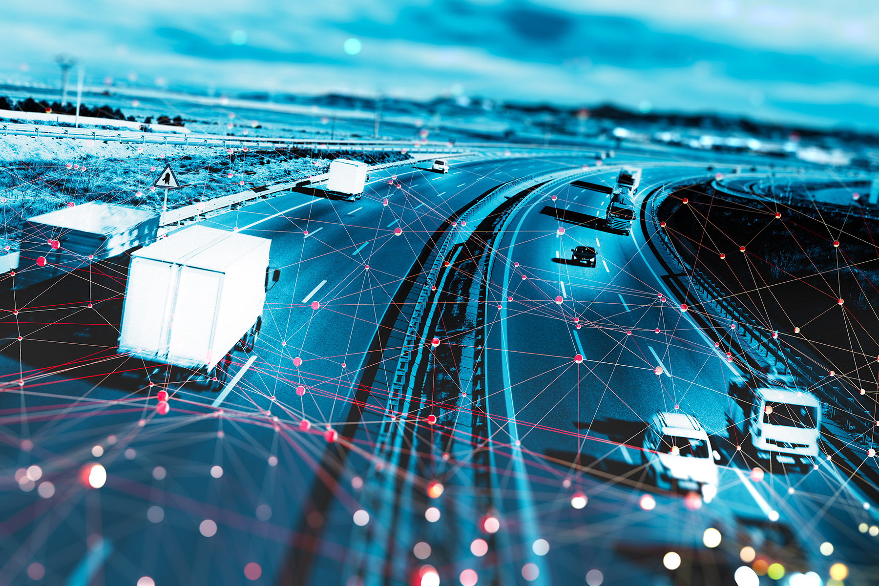 Cars and trucks driving along a highway are linked by lines and nodes of reddish light, suggesting a technological connection.