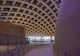 The interior of the Wisdome Stockholm depicts the crisscrossing roof beams and the edge of the domed arena. 