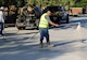 a man sprays coating on a street from a hose