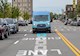 blue van drives along a street