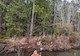 a person stands waist-deep in water with surveying equipment